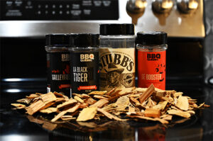 Picture of four kinds of BBQ spice on a kitchen stove with wood chips